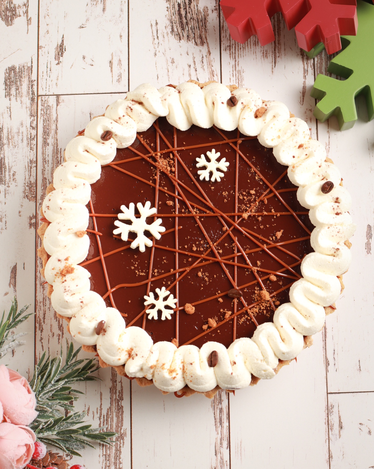 Holiday chocolate tart with whipped cream and snowflake decor