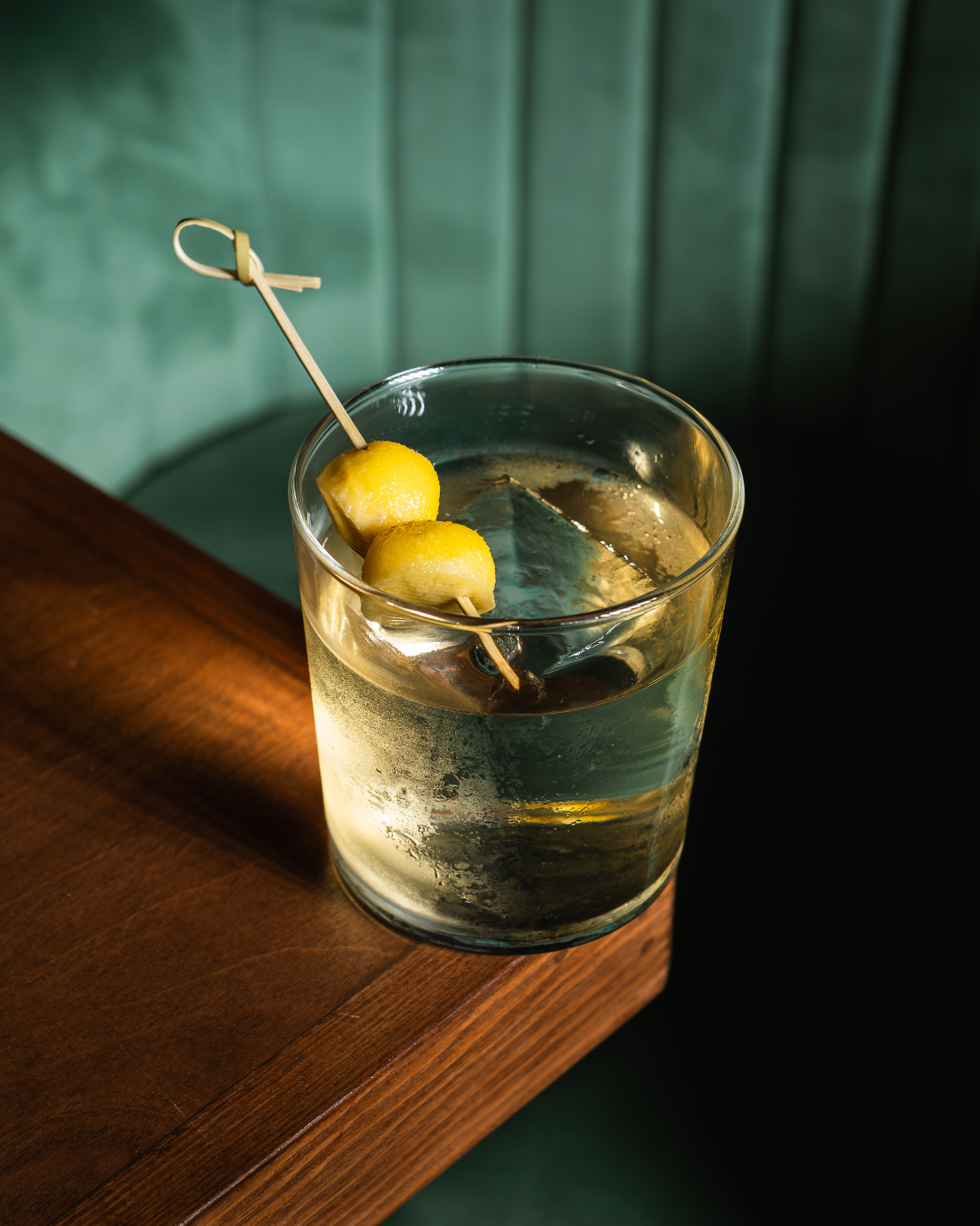Cocktail on a wooden bar with green backdrop