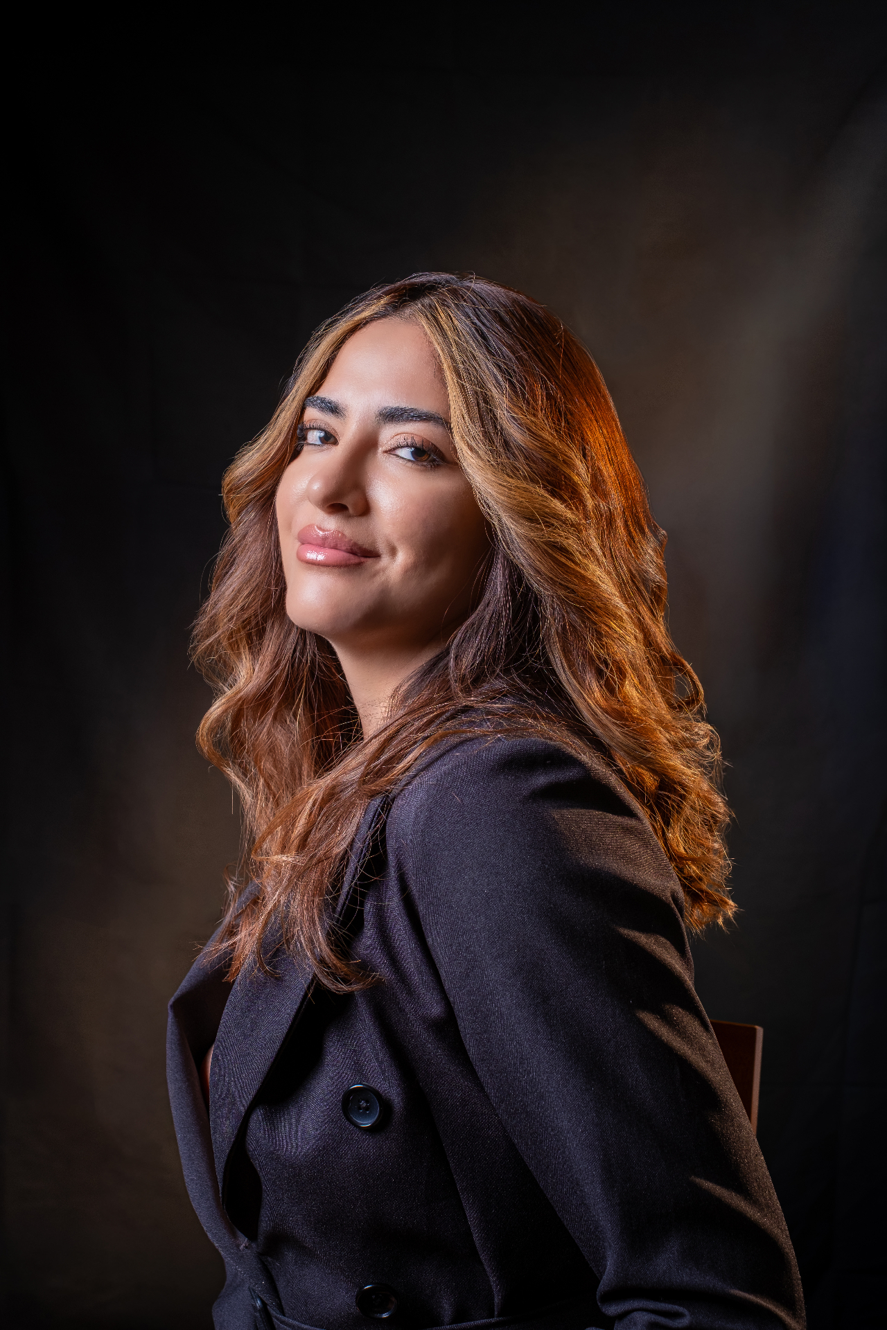 Warm-lit portrait against a black backdrop