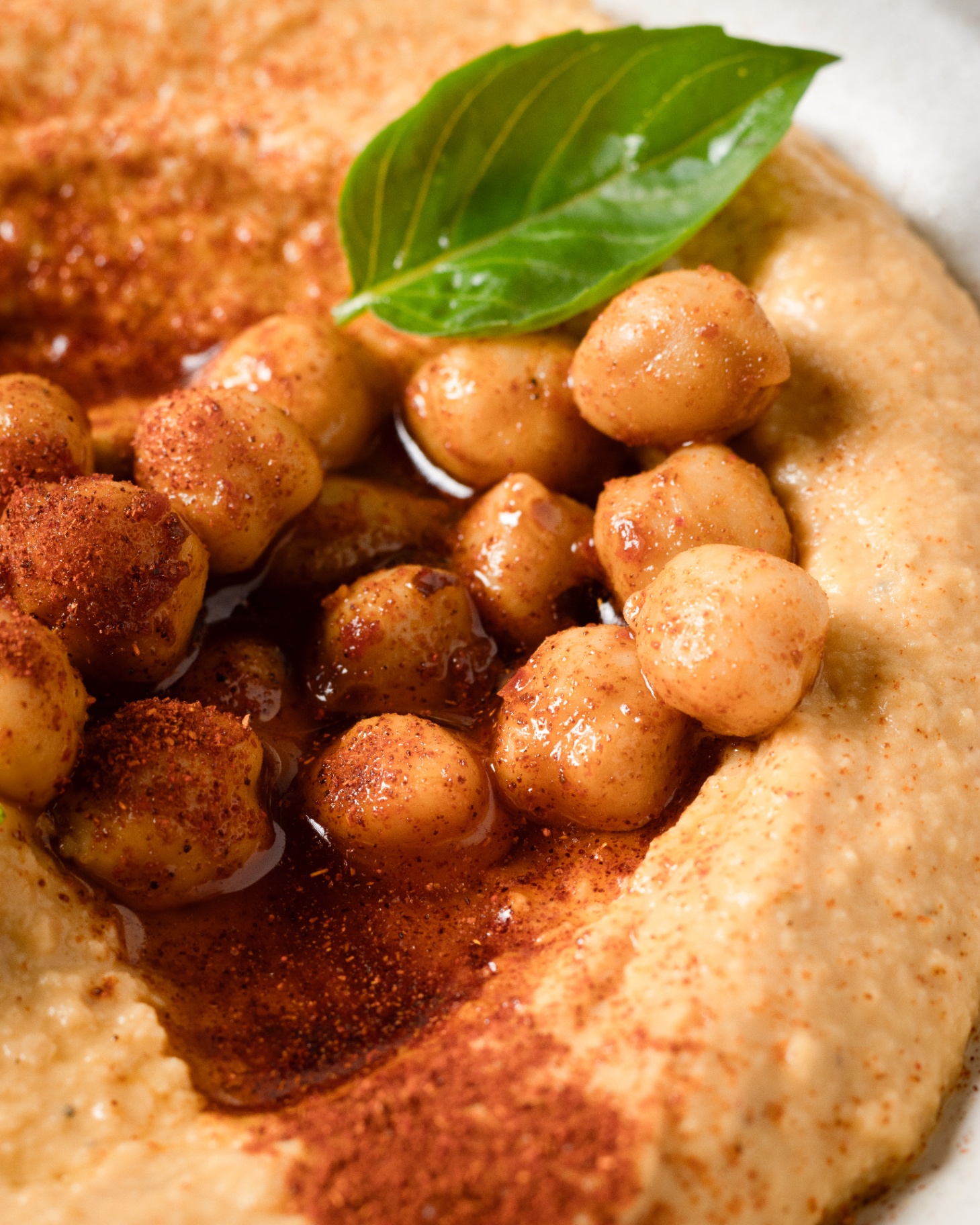 Hummus close-up with chickpeas, paprika and basil