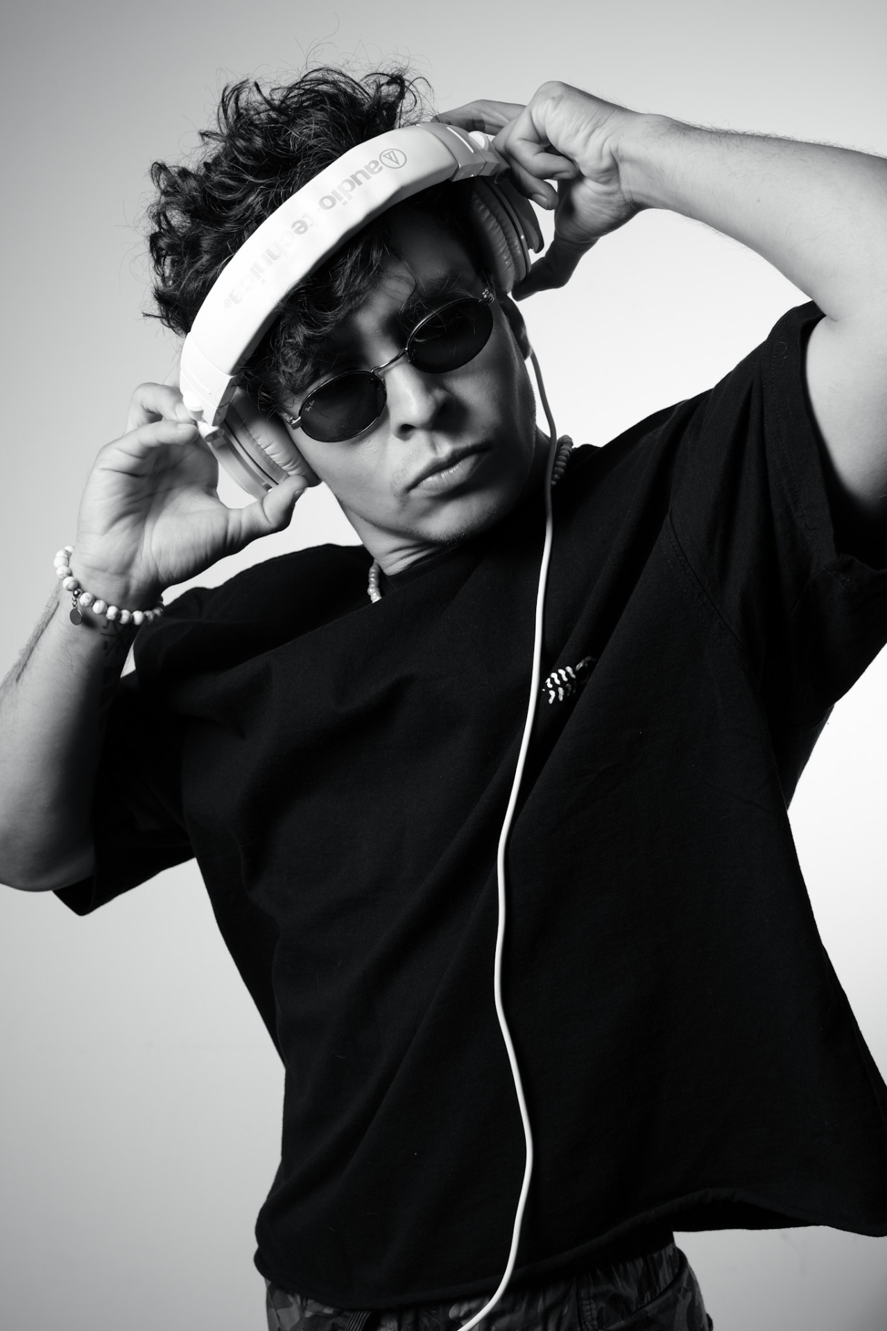Black and white portrait with headphones and dark sunglasses