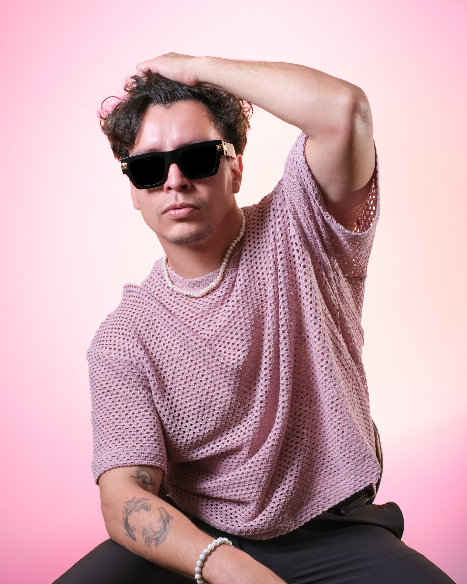 Studio portrait with black sunglasses on a pink backdrop